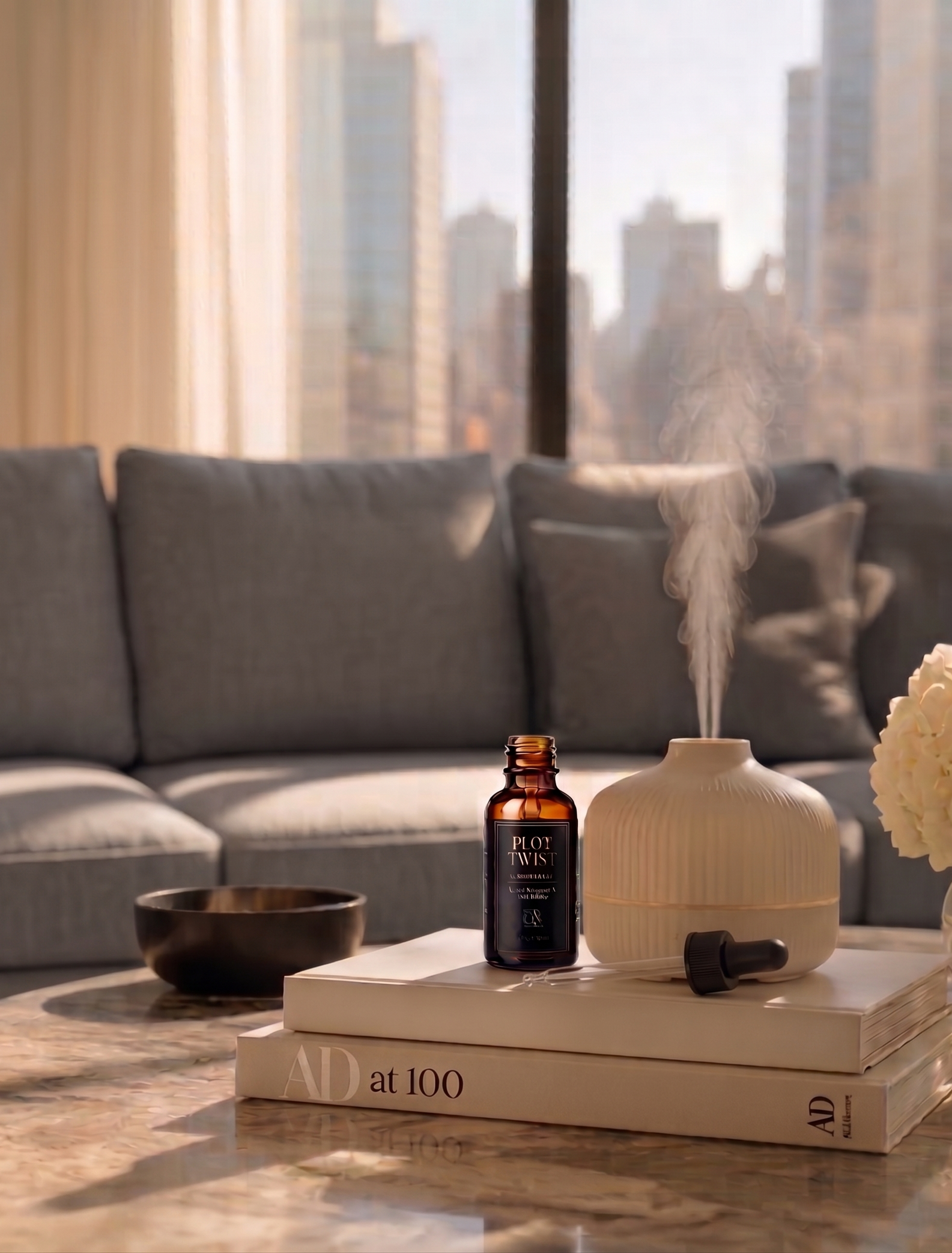 Plot Twist Lux Oil Blend bottle next to an active misting diffuser on a coffee table in a cozy, elegant living room.